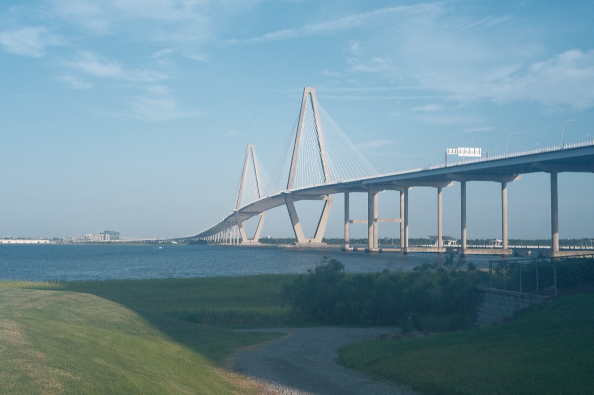 The Ravenel Bridge's white cable towers stretching across the harbor on a clear evening